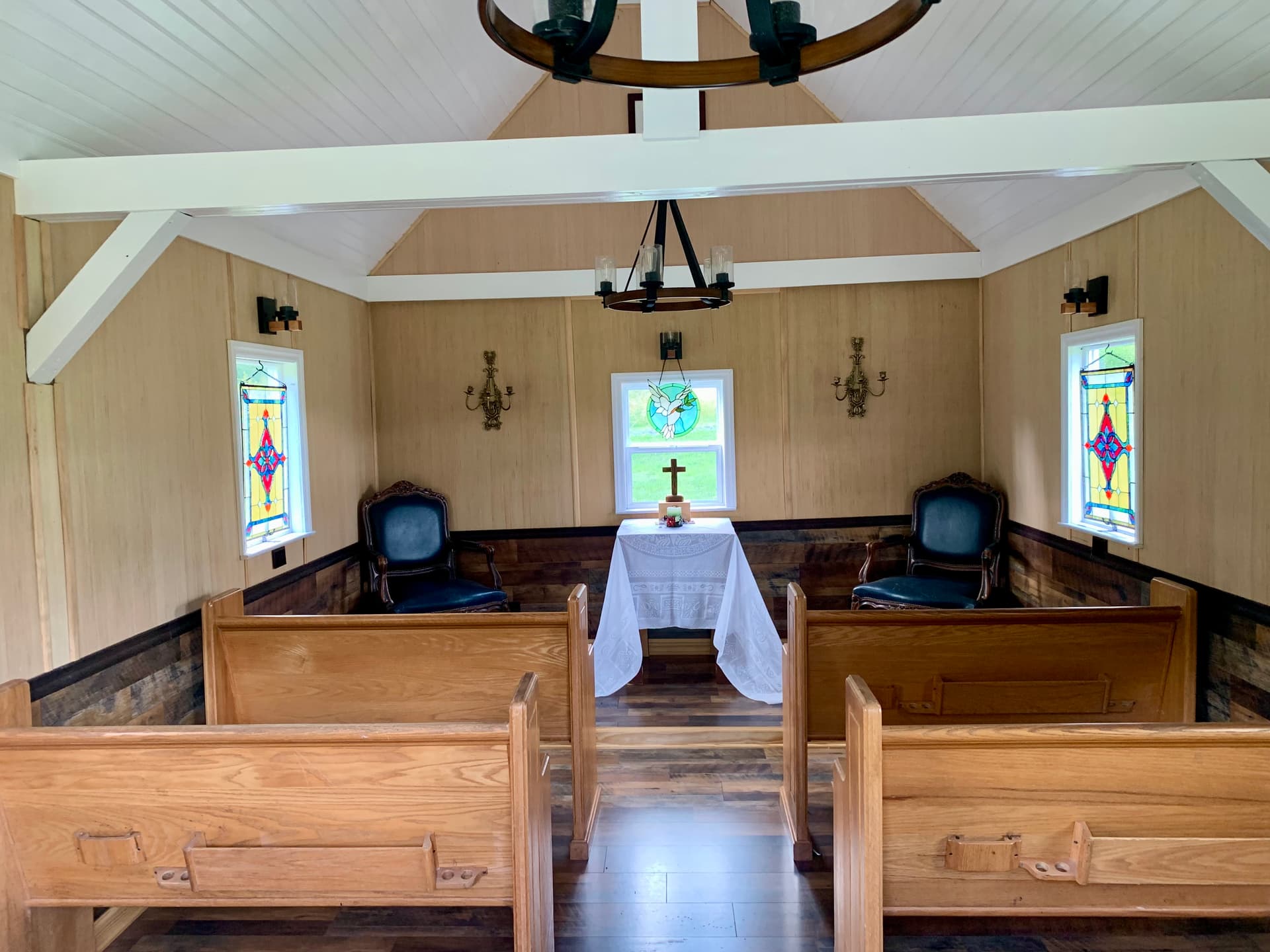 Chapel interior with pews, altar, and stained glass windows